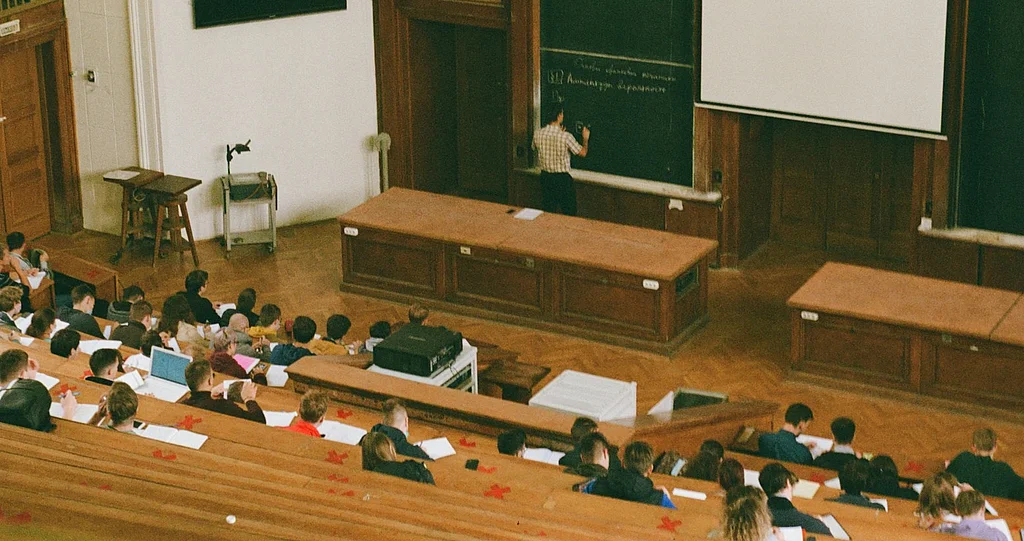 People sitting on brown wooden bench in lecture